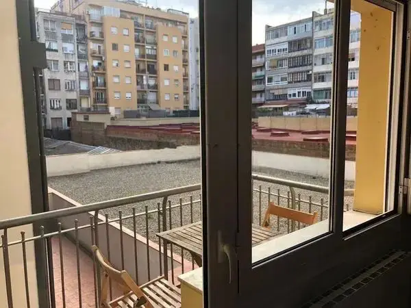Fully furnished student apartment room in C/ de Muntaner 89 Barcelona with double bed, study desk, wardrobe, and natural light