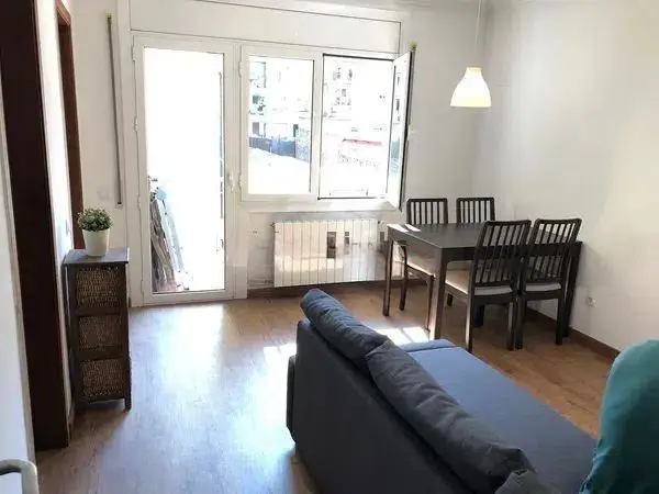 Fully furnished student apartment room in C/ de Muntaner 89 Barcelona with double bed, study desk, wardrobe, and natural light