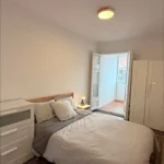Bright student room in Eixample Barcelona with private bathroom, balcony, and double bed
