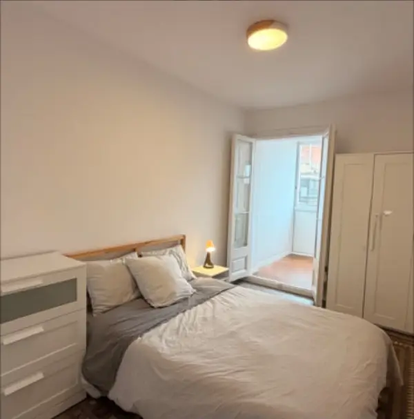Bright student room in Eixample Barcelona with private bathroom, balcony, and double bed