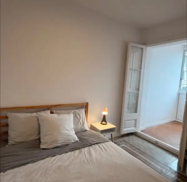 Bright student room in Eixample Barcelona with private bathroom, balcony, and double bed