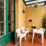 Spacious student room in Plaça Urquinaona Barcelona with double bed, study desk, and shared terrace