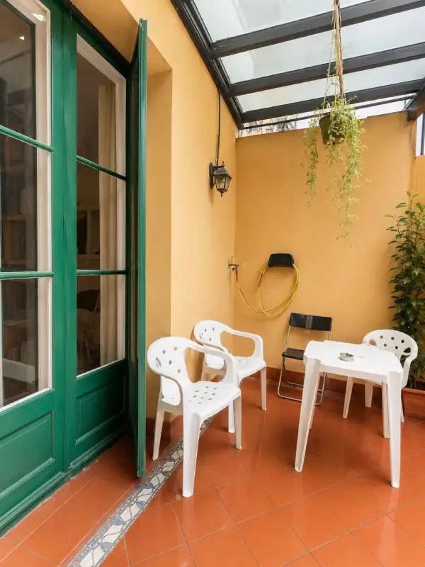 Spacious student room in Plaça Urquinaona Barcelona with double bed, study desk, and shared terrace