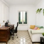 Spacious student room in Plaça Urquinaona Barcelona with double bed, study desk, and shared terrace
