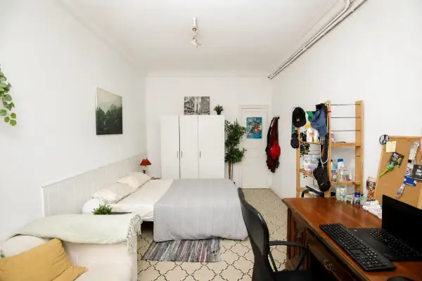 Spacious student room in Plaça Urquinaona Barcelona with double bed, study desk, and shared terrace